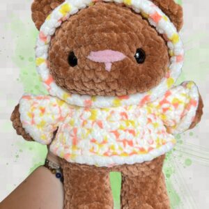 Rust brown crochet bear plushie in a yellow and orange speckled hoodie - front view
