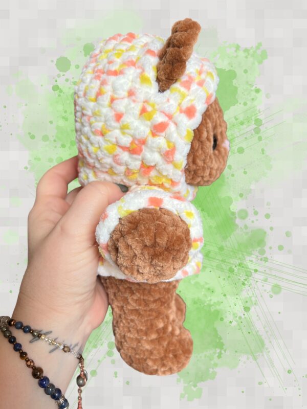 Rust brown crochet bear plushie in a yellow and orange speckled hoodie - right view