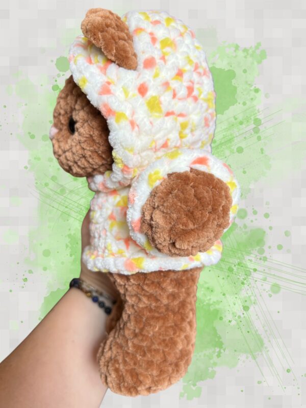 Rust brown crochet bear plushie in a yellow and orange speckled hoodie - left view