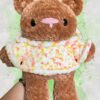 Rust brown crochet bear plushie in a yellow and orange speckled hoodie - front view no hood