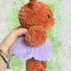 plush rust brown bear in a lavender dress